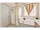 Bright bathroom features a glass block window, soaking tub, and a glass-enclosed shower at 6887 S Teresa Dr, Chandler, AZ 85249