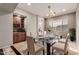 Elegant dining room showcasing a modern glass table, chandelier, and a convenient built-in bar area at 6887 S Teresa Dr, Chandler, AZ 85249