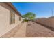 Exterior side view showing a walkway, window shutters, and low maintenance desert landscaping with rocks and plants at 6887 S Teresa Dr, Chandler, AZ 85249