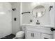 Modern bathroom features a glass walk-in shower and a decorative, round mirror at 725 W Palo Verde St, Gilbert, AZ 85233