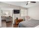 Well-lit bedroom offering hardwood floors, a ceiling fan, and easy access to a connected living space at 7625 E Camelback Rd # A110, Scottsdale, AZ 85251