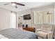 Bright bedroom features a ceiling fan, TV, recliner, and view into the living area at 7625 E Camelback Rd # A110, Scottsdale, AZ 85251