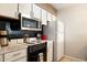 Efficient kitchen featuring white cabinets, a microwave, an electric stove, and modern appliances at 7625 E Camelback Rd # A110, Scottsdale, AZ 85251