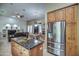 The open concept kitchen flows into the living area, featuring wood cabinets, stainless appliances, and a center island at 907 W Restin Rd, Phoenix, AZ 85086