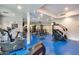 Well-equipped community gym with a variety of exercise machines and weights on blue floors at 945 E Playa Del Norte Dr # 1012, Tempe, AZ 85288