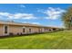 Spacious backyard with lush green lawn extending between houses and a blue sky above at 9606 W Shasta Dr, Sun City, AZ 85351