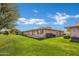 Backyard view featuring lush green lawns and a clear blue sky with fluffy white clouds at 9606 W Shasta Dr, Sun City, AZ 85351