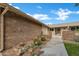Inviting entrance area with brickwork, desert landscaping, and decorative gate at 9606 W Shasta Dr, Sun City, AZ 85351