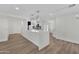 Bright, open-concept kitchen with white countertops, modern lighting, and wood-look flooring at 9606 W Shasta Dr, Sun City, AZ 85351