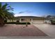 Charming single-story home with desert landscaping, a spacious driveway, and an attached two-car garage at 10110 W Sombrero Cir, Sun City, AZ 85373