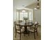 Cozy dining room featuring a round wood table, six chairs and bright natural light from the adjacent windows at 10226 E Pine Valley Rd, Scottsdale, AZ 85255
