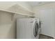 A well-organized laundry area featuring modern appliances and convenient overhead storage shelving at 10226 E Pine Valley Rd, Scottsdale, AZ 85255