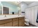 Well-lit bathroom featuring a double sink vanity with wood cabinetry and shower at 10359 E Jacob Ave, Mesa, AZ 85209