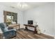 Bright living room featuring wood-look floors, a comfortable chair, and a piano at 10359 E Jacob Ave, Mesa, AZ 85209