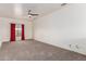 Bright bedroom featuring a ceiling fan, neutral walls, carpet, and a window with red curtains at 10434 E Jacob Ave, Mesa, AZ 85209