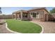 Well-maintained home with a backyard featuring artificial turf, gravel, and a covered patio at 10859 E Thatcher Ave, Mesa, AZ 85212