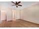 Bright bedroom featuring neutral walls, wood-look floors, ceiling fan, and trim detail at 10859 E Thatcher Ave, Mesa, AZ 85212