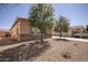 Attractive single-story home with desert landscaping, trees, and a stone accent wall at 10859 E Thatcher Ave, Mesa, AZ 85212