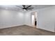 Spacious bedroom with carpet, ceiling fan, and en suite bathroom entrance at 11612 S 211Th Ln, Buckeye, AZ 85326