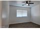 Bright bedroom featuring neutral carpeting, ceiling fan, and a window for natural light at 11612 S 211Th Ln, Buckeye, AZ 85326