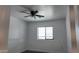 Bright bedroom features neutral carpeting, ceiling fan, and a window for natural light at 11612 S 211Th Ln, Buckeye, AZ 85326