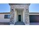 Inviting front entrance with stone accents, modern lighting, and a stylish black door at 11612 S 211Th Ln, Buckeye, AZ 85326