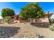 Expansive backyard with desert landscaping, covered patio and a mature shade tree for outdoor enjoyment at 12423 W Fieldstone Dr, Sun City West, AZ 85375