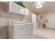 Bright laundry room featuring white cabinets, ample storage space, and a modern washer and dryer at 12423 W Fieldstone Dr, Sun City West, AZ 85375