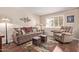 Comfortable living room featuring hardwood floors, a plush sofa, and a recliner at 12423 W Fieldstone Dr, Sun City West, AZ 85375