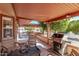 Covered patio featuring a grill, tile flooring and wood-look patio furniture, perfect for outdoor entertaining at 12423 W Fieldstone Dr, Sun City West, AZ 85375