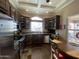 Well-lit kitchen featuring dark wood cabinetry, stainless steel appliances, and a cozy breakfast nook with large windows at 1277 S Shawnee Dr, Apache Junction, AZ 85119