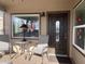 Cozy covered front porch area with comfortable seating, a dark wooden door and ample natural light at 1277 S Shawnee Dr, Apache Junction, AZ 85119