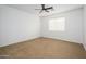 Empty bedroom with neutral carpet, a ceiling fan, and a large window, bathed in natural light at 1280 E Redwood Dr, Chandler, AZ 85286