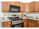 Close-up of kitchen features, granite counters, stainless steel gas range, and wood cabinets with modern black hardware at 1280 E Redwood Dr, Chandler, AZ 85286