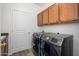 Modern laundry room featuring updated washer and dryer units with custom wooden cabinets at 1280 E Redwood Dr, Chandler, AZ 85286