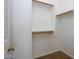 Empty walk-in closet featuring neutral carpet, custom shelving, and wooden rods at 1280 E Redwood Dr, Chandler, AZ 85286
