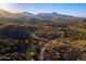 Wide aerial shot of the desert landscape featuring winding roads leading to luxury homes at 16856 N Mountain Pkwy, Fountain Hills, AZ 85268
