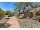 Community entrance with signage, a wooden fence, mature trees, and well-maintained landscaping at 16856 N Mountain Pkwy, Fountain Hills, AZ 85268