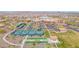 Aerial view showcases the community's tennis courts, lake, and amenity center with beautiful landscaping at 18059 W Tanglewood Dr, Goodyear, AZ 85338