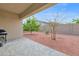Covered patio extends to a backyard featuring desert landscaping and mature trees at 18059 W Tanglewood Dr, Goodyear, AZ 85338