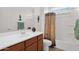 Bright bathroom features a vanity with drawers, decorative accents, and a tub with shower at 18059 W Tanglewood Dr, Goodyear, AZ 85338