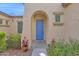 Inviting home entrance featuring a blue door, stone walkway and colorful potted plants for added curb appeal at 18059 W Tanglewood Dr, Goodyear, AZ 85338