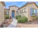 Inviting front entrance with a blue door, landscaped yard, and a charming walkway leading to the home at 18059 W Tanglewood Dr, Goodyear, AZ 85338