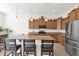 Gourmet kitchen featuring a granite island with seating, stainless steel appliances, and pendant lighting at 18059 W Tanglewood Dr, Goodyear, AZ 85338