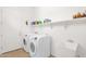 Laundry room with modern washer and dryer, utility sink, and storage shelves at 18059 W Tanglewood Dr, Goodyear, AZ 85338