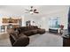 Open-concept living room featuring a ceiling fan, carpet, and natural light from a window at 18059 W Tanglewood Dr, Goodyear, AZ 85338