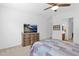 Cozy main bedroom featuring a comfortable bed with quilt, a TV, dresser, and an ensuite bathroom at 18059 W Tanglewood Dr, Goodyear, AZ 85338