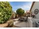 Backyard patio with seating area, BBQ grill, lush landscaping, and exterior home features at 20615 N 105Th Ave, Peoria, AZ 85382