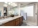 Bathroom features dual sinks, granite counters, framed mirror, and glass shower at 20615 N 105Th Ave, Peoria, AZ 85382