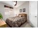 Bedroom featuring a window with blinds, ceiling fan, and patterned bedspread at 20615 N 105Th Ave, Peoria, AZ 85382